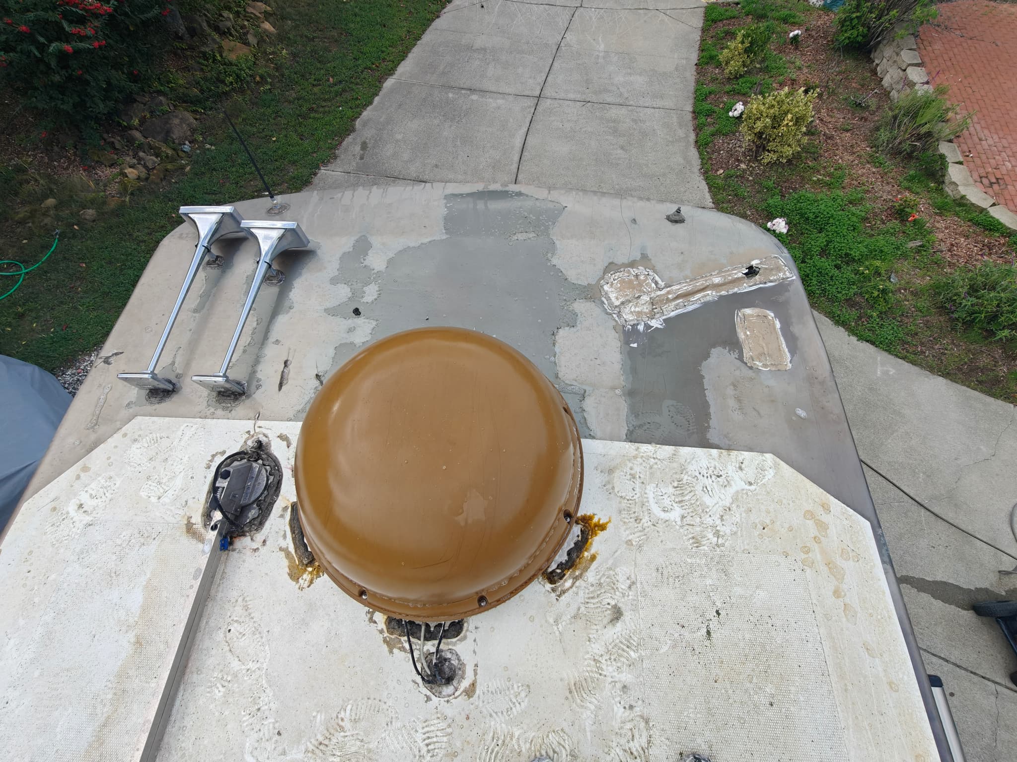 Rust and deteriorated sealant around antenna on RV roof before maintenance