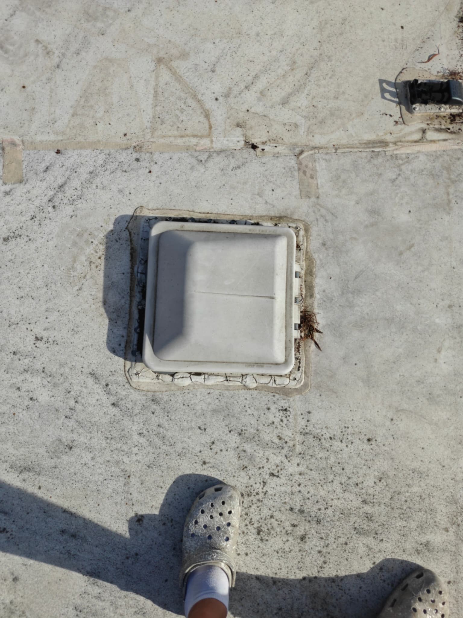 Damaged and cracked sealant around roof vent on RV before maintenance