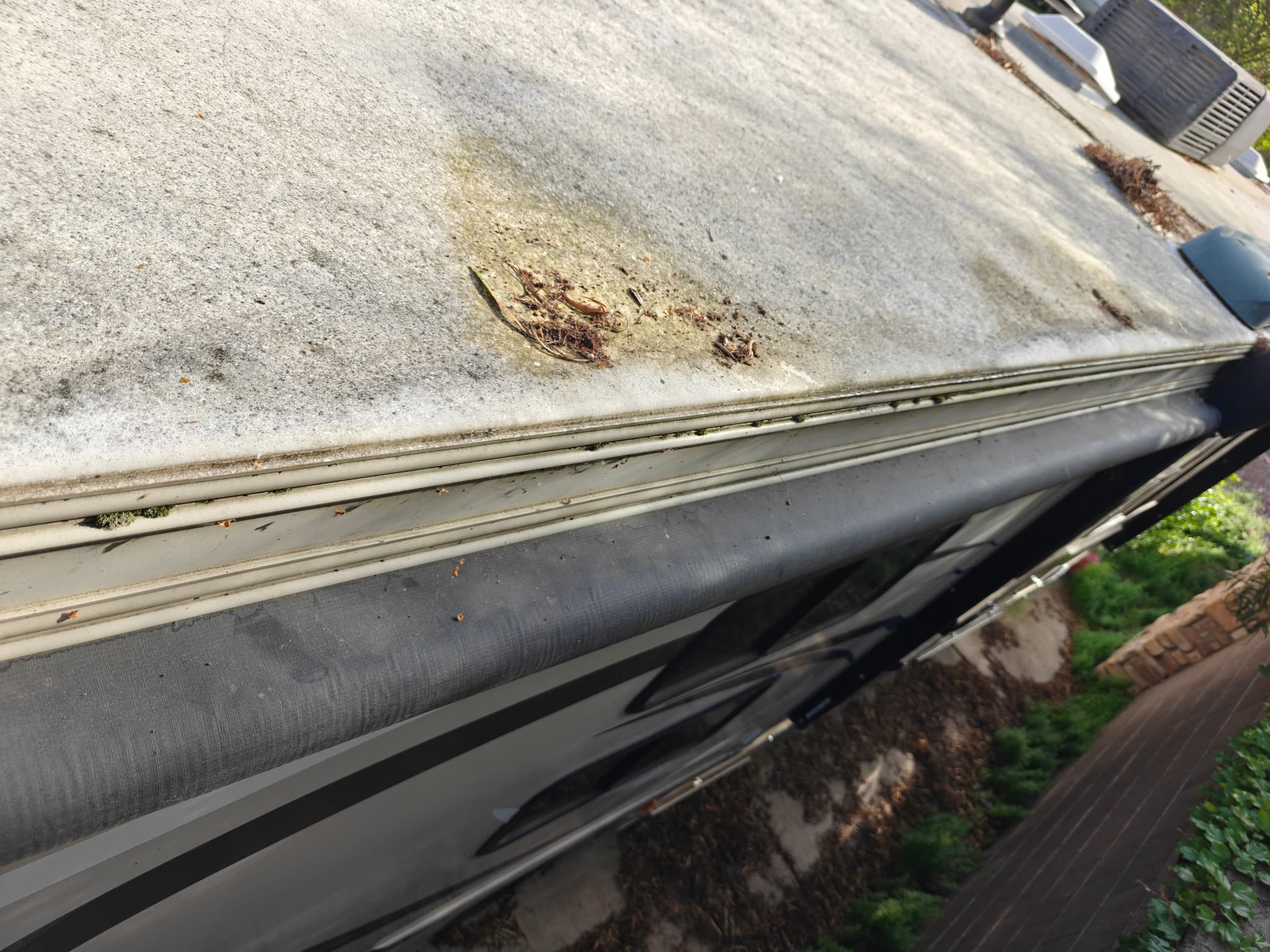 Dirty RV roof side with gutter before maintenance