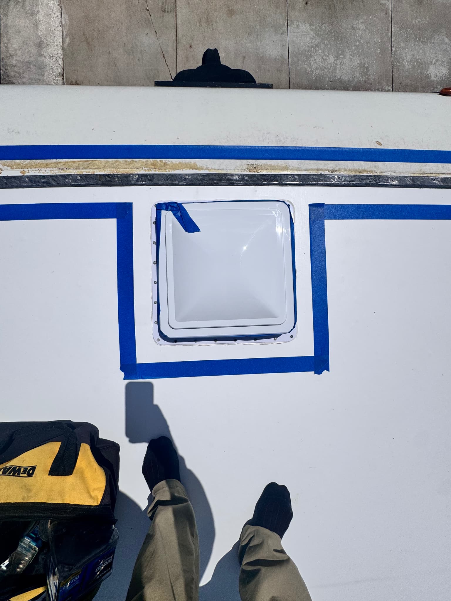 Masking tape applied around vent and termination bar before sealing on RV roof