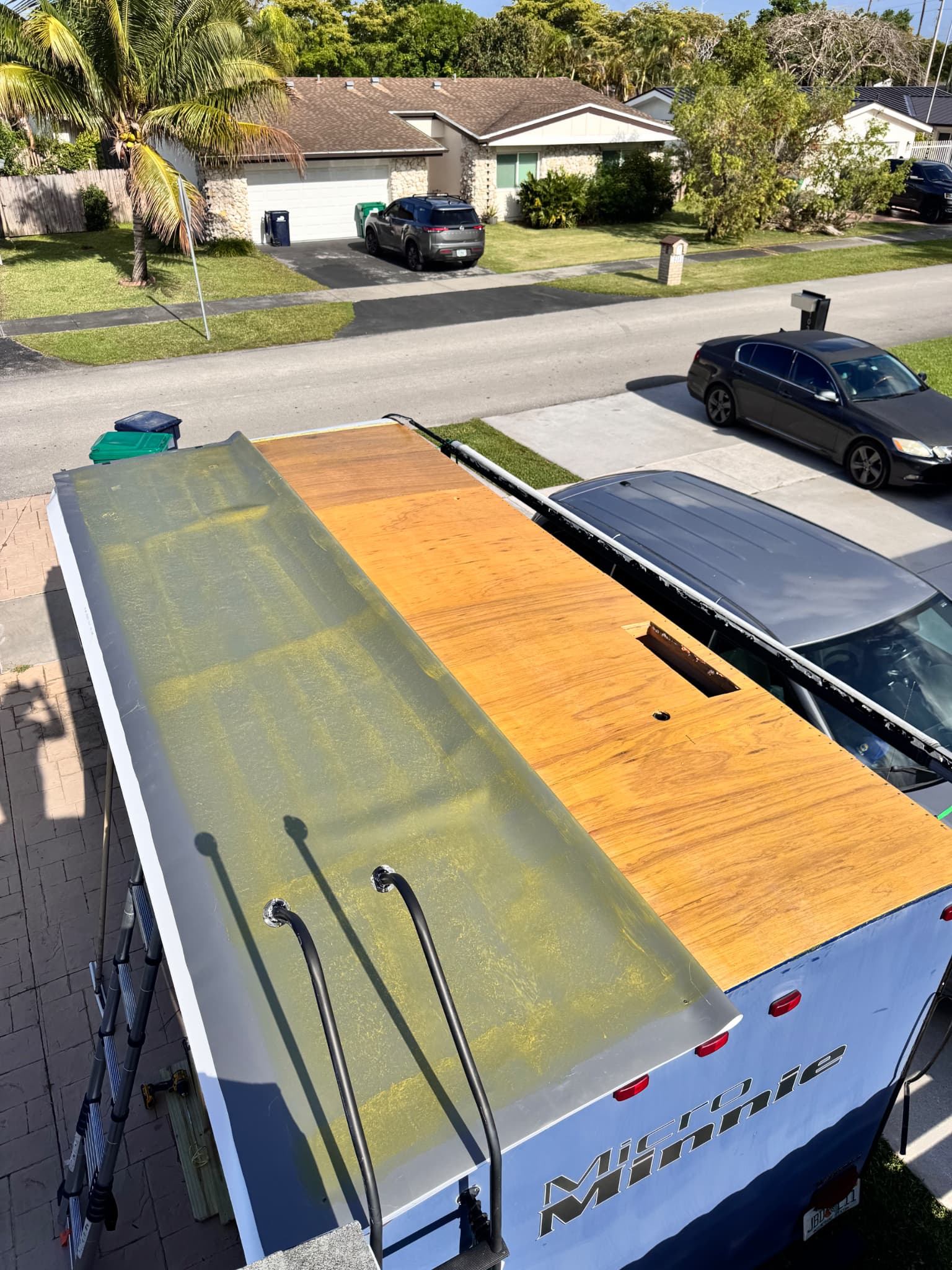 Applying adhesive and installing TPO membrane on RV roof during replacement