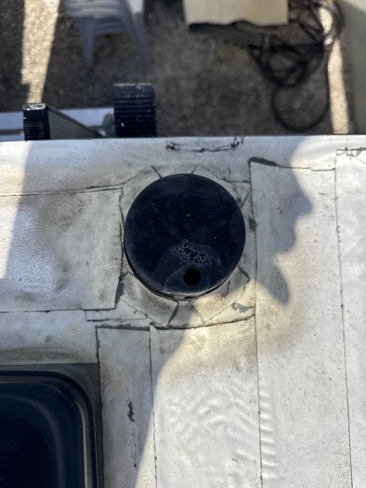 RV roof antenna covered with tape over sealant showing failed repair and leaks