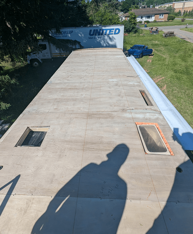 New plywood decking installed across the entire RV roof before PVC membrane installation